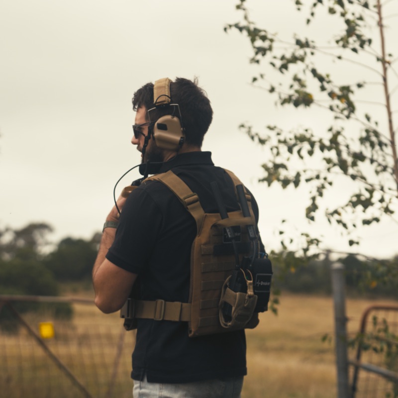 An operator seen from behind on the radio, plate carrier and headset.