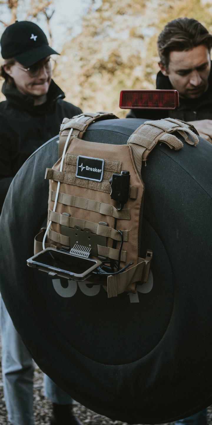 A plate carrier with a Breaker patch, rigged and ready beside two colleagues.