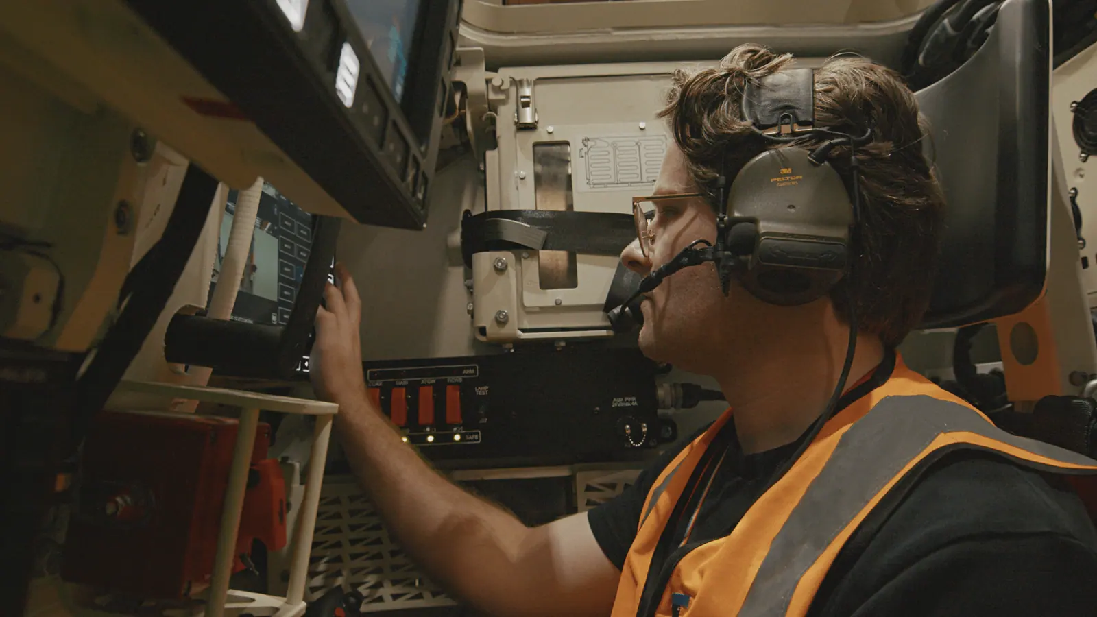 Lachlan Watson of Rheinmetall Defence Australia in the Boxer operator seat, speaking into his headset microphone.