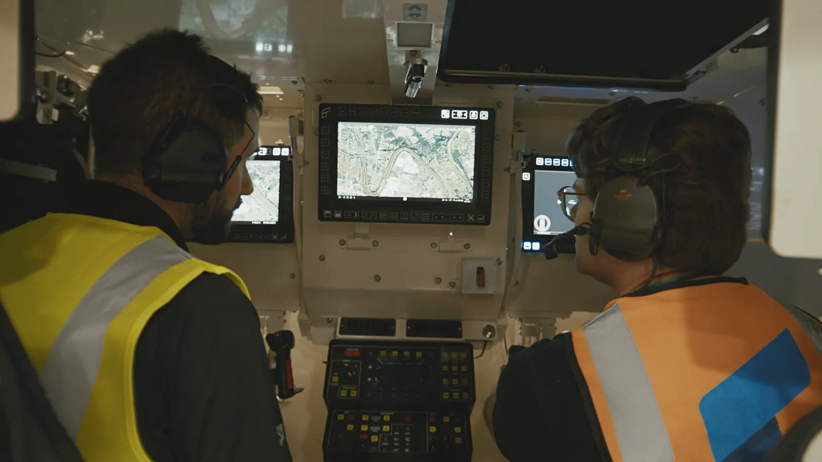 Vanja Videnovic of Breaker and Lachlan Watson of Rheinmetall Defence Australia at the Boxer training simulator, a map on the screen between them.